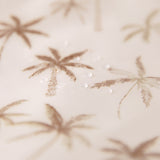 Close-up of water droplets on Bumkins Sleeved Bib: Palm Daze.