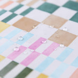 Close-up of water droplets on Bumkins Sleeved Bib: Motley Check.