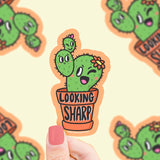Turtle Soups Lookin Sharp vinyl sticker features a cute winking cactus in a pot, surrounded by blurry cactus illustrations.