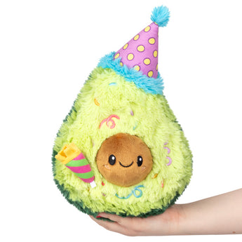 The Squishable Plush Birthday Avocado, made with polyester fiber, sports a party hat and smile—ideal for any age!.
