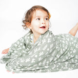 A toddler smiles, wrapped in Emerson and Friends Stay Sharp bamboo blanket featuring a cactus print.