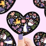 Turtle Soup Vinyl Sticker, Winter Heart: Heart-shaped with penguins, snowflakes, cocoa & mittens. Durable & waterproof on black.
