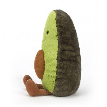 Side view of Jellycats Amuseables Avocado Large plush toy: green front, fuzzy dark brown back, sitting with small brown legs.