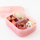 A bento box from Bumkins Lunchbox Legends 6-Piece Set: Watercolor Pink Jelly holds snacks on a white background.