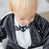 A toddler wearing Bumkins Sleeved Bib: Jack Skellington looks downward.