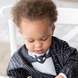 A young child wearing a Bumkins Sleeved Bib: Jack Skellington, looking down with a serious expression.