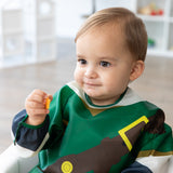 A child in a bib from Bumkins Snack In Character 4-Piece Set: Nintendo Zelda holds an orange cracker.