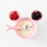 Bumkins Silicone First Feeding Set: Minnie Mouse Light Pink filled with yogurt, chia seeds, and berries on a white background.