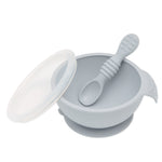 Bumkins Silicone First Feeding Set: Gray includes a bowl with suction bottom, a matching spoon, and a transparent lid.