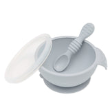 Bumkins Silicone First Feeding Set: Gray includes a bowl with suction bottom, a matching spoon, and a transparent lid.