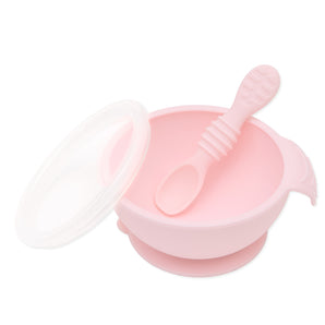 Bumkins Silicone First Feeding Set: Pink includes a bowl with suction bottom, a matching spoon, and a transparent lid.