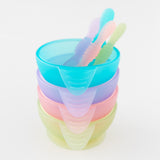 A stack of four colorful bowls with spoons, on a white background, with Bumkins Silicone First Feeding Set: Green Jelly on the bottom.