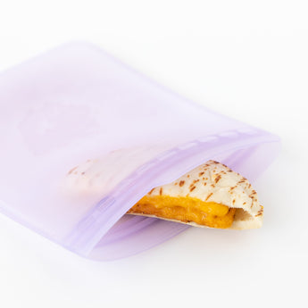 A sandwich with melted cheese is visible inside an open Bumkins Silicone Flat Reusable Bag 2 Pack, Lavender on a white background.