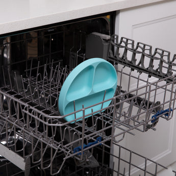 Bumkins Silicone Grip Dish: Blue sits in the top rack of an open dishwasher.
