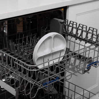 Bumkins Silicone Grip Dish: Marble sits in the top rack of an open dishwasher.