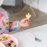 Close-up of a child enjoying a cactus-shaped snack with Bumkins On-The-Go Mealtime 6-Piece Set: Boots + Pink.