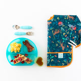 Scrambled eggs, bacon, and waffles in a Bumkins Silicone Grip Dish: Blue Jelly, with cutlery and bright bib nearby on a white background.