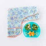 Bumkins Grip Dish Deluxe Infant 5-Piece Mealtime Set: Blue Jelly with fruit & veggies sits next to a folded bib on a white background.