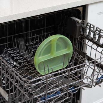 Bumkins Silicone Grip Dish: Green Jelly sits in the top rack of an open dishwasher.
