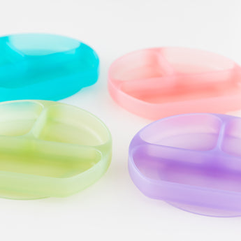 Four colorful dishes, including Bumkins Silicone Grip Dish: Green Jelly, are arranged on a white background.