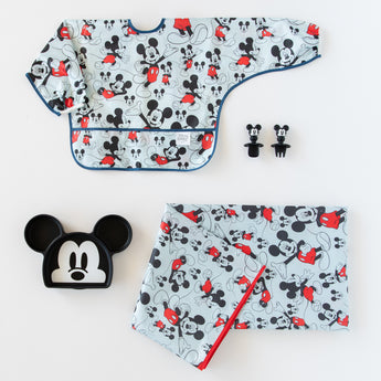 Bumkins Disney Little Ones Gift Bundle: Mickey Mouse Classic includes a sleeved bib, Silicone Chewtensils®, splat mat, and silicone grip dish.