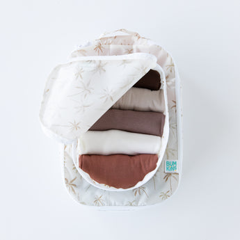 A top down view of Bumkins Packing Cube 2 Pack: Palm Daze stacked on a white background. The top cube is open and holds folded clothes.