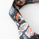 Close-up of Bumkins Packable Tote Bag: Ghostly Gallery on a white background, highlighting the snap closure on the straps.