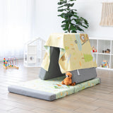 A playroom with a cushion tent using a Bumkins Reversible Roll & Go Blanket, Happy Camper, with blocks, a stuffed animal, and a plant nearby.