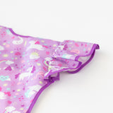 Close-up of Bumkins Ruffle Apron Bib: Unicorns laid flat on a white background, with focus on the ruffle sleeve.