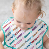 A child wearing a white Bumkins SuperBib® 3 Pack: Mickey & Friends MVP cartoon names like Mickey, Minnie, Pluto & Goofy.