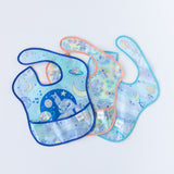 Bibs from Bumkins On-The-Go Mealtime 7-Piece Set: Stitch Star-ring Up Trouble lay overlapped on a white background.