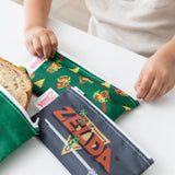 Close-up of a child zipping bags from Bumkins Snack In Character 4-Piece Set: Nintendo Zelda.