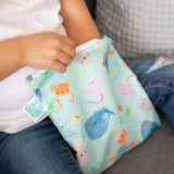 Close-up of a child reaching into a bag from Bumkins Lunchbox Legends 6-Piece Set: Ocean Blue Jelly.