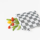 Veggies spill from a Roamio by Bumkins Bumkins Reusable Snack Bag, Large 2 Pack: Double Check on a white background.