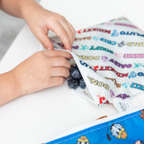 Close-up of a child’s hands reaching into a Bumkins Reusable Snack Bag 4 Pack: Disney Mickey & Friends Crew to grab fresh blueberries.