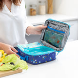 A woman packs a lunch bag with Bumkins Lunchbox Legends 6-Piece Set: Ocean Blue Jelly on a kitchen counter.