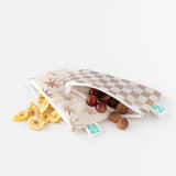Bumkins Reusable Snack Bag, Small 2 Pack: Palm Check lays on a white background, filled with grapes and banana chips.