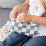 A child opens a Bumkins Reusable Snack Bag, Small 2 Pack: Double Check on a gray couch.