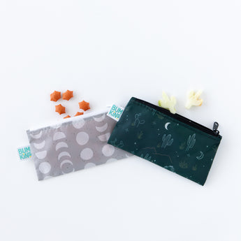 Bumkins Reusable Snack Bag, Small 2 Pack: Desert Night sits on a white background, with star and cactus shaped snacks spilling out of the top.