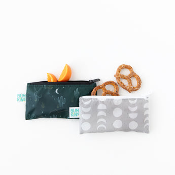 Bumkins Reusable Snack Bag, Small 2 Pack: Desert Night sits on a white background with oranges and pretzels peeking from the tops of the bags.
