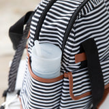 A black and white striped backpack with brown trim has a Bumkins Silicone Straw Cup with Lid: Gray in the side pocket.