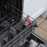 Bumkins Silicone Chewtensils®: Pink Jelly sit in the utensil compartment of an open dishwasher.