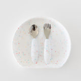 Bumkins Spoon + Fork: Vanilla Sprinkle rests on top of a matching plate on a white background.