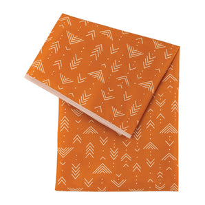 Bumkins Splat Mat: Grounded features easy-wipe orange waterproof fabric with white geometric arrow patterns.