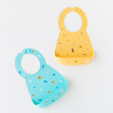 Bumkins Silicone Bib 2 Pack: Ocean Life and Camp Gear lays flat on a white background.