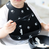 Close-up of a toddler eating yogurt with Bumkins Silicone Feeding 3-Piece Set: Mickey Mouse Faces B+W.