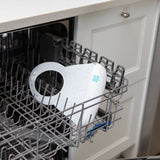 Bumkins Silicone Bib: Vanilla Sprinkle sits in the top rack of an open dishwasher.