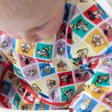 A child in Bumkins Sleeved Bib: Mickey & Friends Check Mates with drops of yogurt on the front of the bib.