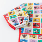 Close-up of Bumkins Sleeved Bib: Mickey & Friends Check Mates on a white background, showcasing the white elastic cuff on the sleeve.