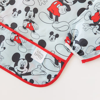 Close-up of Bumkins Sleeved Bib: Mickey Mouse laid flat on a white background, with focus on the front pocket.